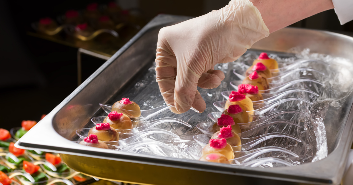 Cocinero con guantes desechables de nitrilo preparando aperitivos, guantes para manipular alimentos