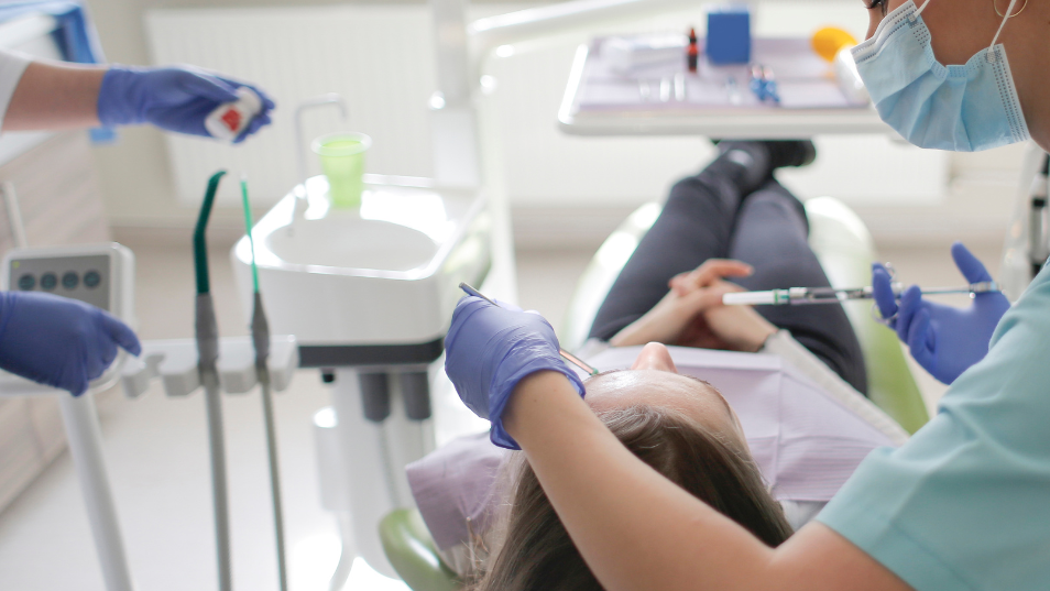 Dentista usando guantes de nitrilo para tratar a su paciente