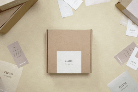 Manos acariciando suavemente una caja de embalaje personalizado, destacando su textura y diseño de marca