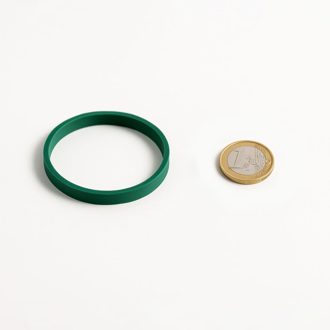 Nuestras gomas elásticas gruesas verdes comparando su tamaño con un euro